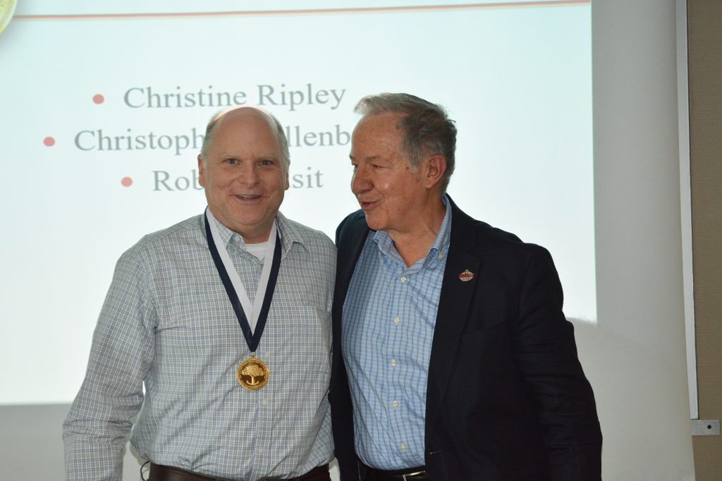 Dr. Michael Fiore presents a medal to Adsit for his years of service.