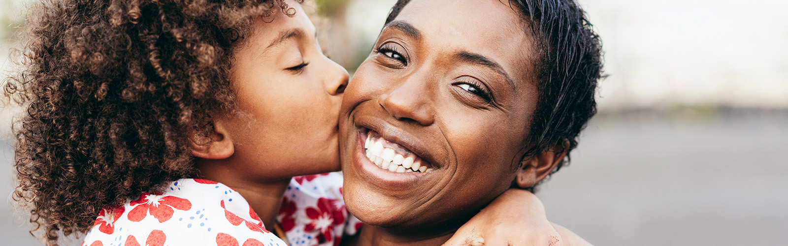 A daughter kisses her mom on the cheek